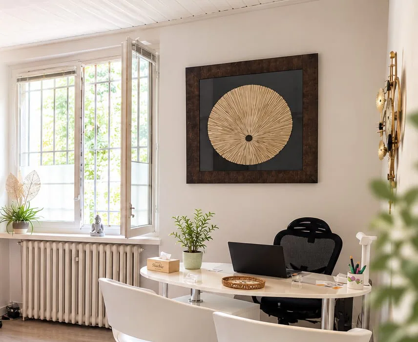 Le cabinet du Petit-Saconnex : bureau blanc, fenêtre ouverte sur les arbres et tableau doré